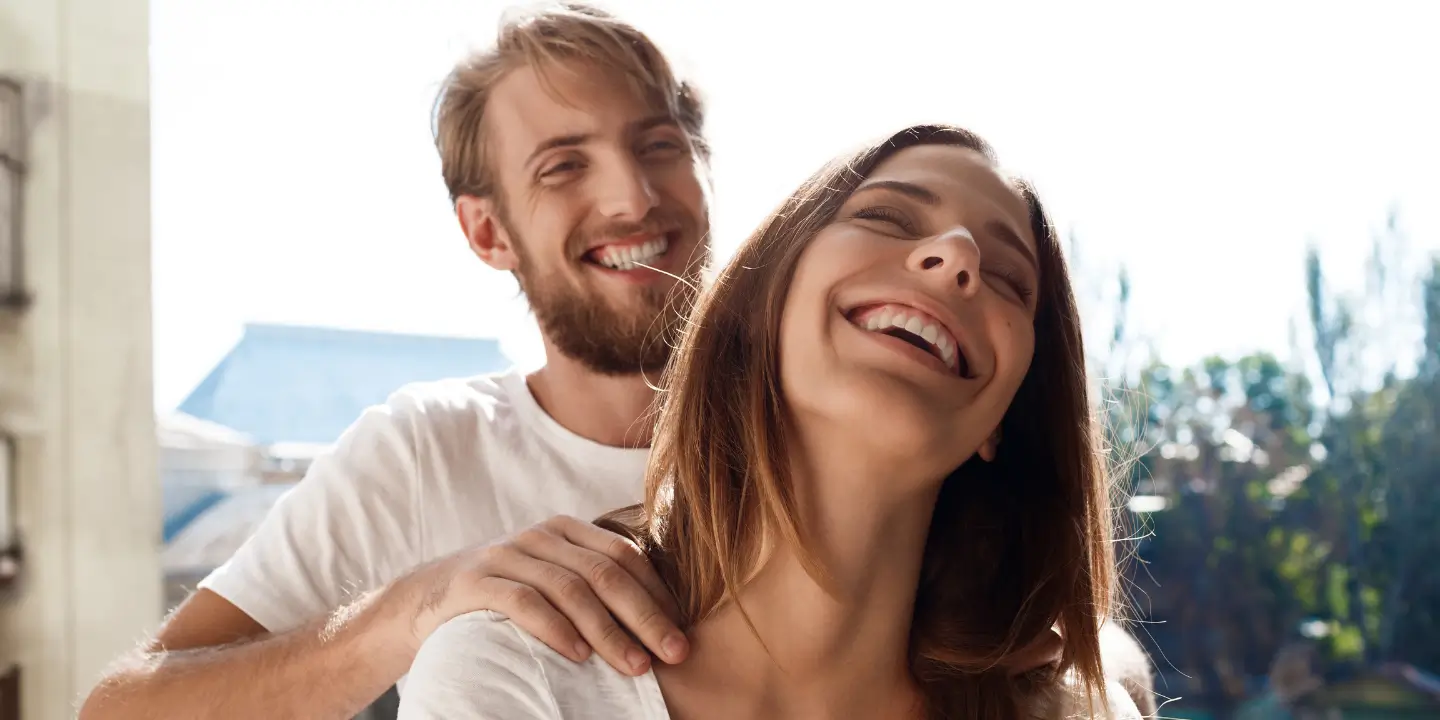 man massaging woman on her shoulders as they smile